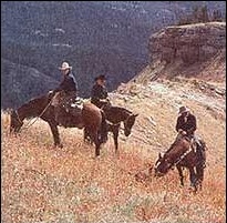 Cowboys on horseback, a quintessential American symbol.